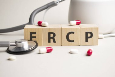Ercp kelimesi sarı arkaplandaki ahşap küplerden ve haplardan oluşur. tıbbi tedavi, önleme ve yan etkiler kavramı.