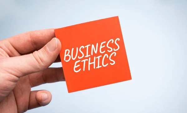 ビジネスマンの手に紙にビジネス倫理の言葉 — ストック写真