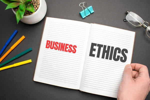 ビジネスマンの手でノートブック上のビジネス倫理テキスト — ストック写真