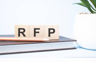 rfp acronym on building blocks supported by two different size pencils. Copy space.
