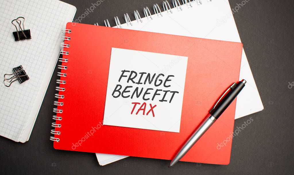 FRINGE BENEFIT TAX sign on sheet of paper on the red notepad with pen