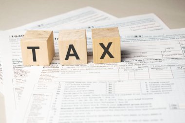 Wooden cubes on 1040 individual tax form. Tax concept