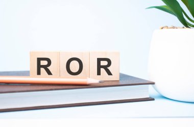 ROR acronym on building blocks supported by two different size pencils. Copy space.