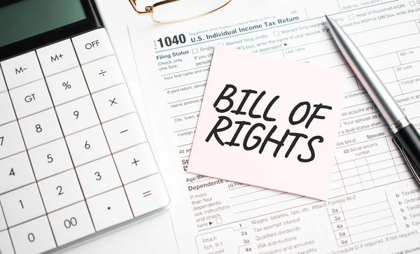 BILL OF RIGHTS with pen, calculator, glass and sticker. Tax report sign