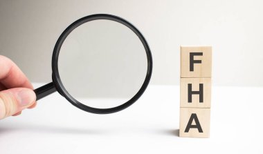 Lettering FHA on wooden cubes on a gray background