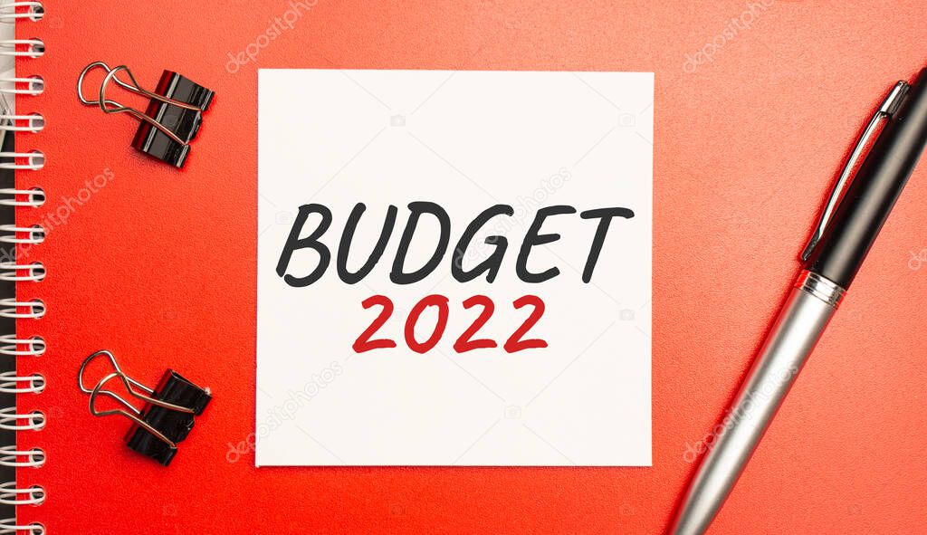 BUDGET 2022 sign on sheet of paper on the red notepad with pen