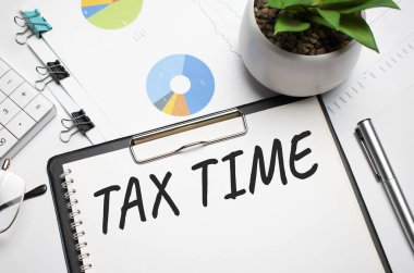 Tablo, hesap makinesi ve para üzerinde Vergi Zamanı olan kağıt