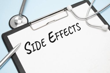 Açık mavi bir masada bir steteskop, bir kalem ve üzerinde EFFECTS yazılı bir kağıt var. Tıbbi konsept