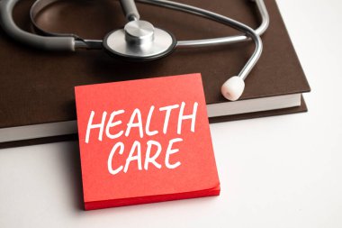 Steteskop ve haplarla mavi arka planda metin sağlığı özeti olan kağıt