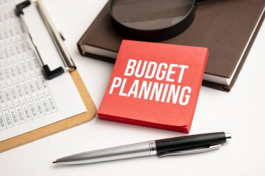 Kağıt tabaka ve kalem üzerinde bütçe planlı büyüteç