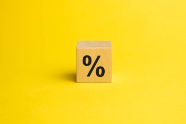 Tahta küplerdeki yüzde işareti, fotokopi alanı olan sarı arka plana karşı. Satış ve indirim kavramı.