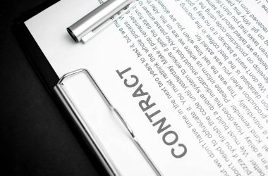 Doküman kontratındaki gümüş kalemin yakın çekimi. Yasal sözleşme imzalamak, gayrimenkul sözleşmesi satın almak kağıt üzerinde siyah kalemle anlaşma imzalamak