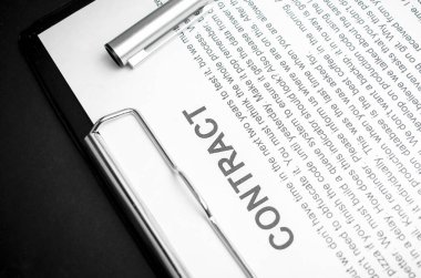 Doküman kontratındaki gümüş kalemin yakın çekimi. Yasal sözleşme imzalamak, gayrimenkul sözleşmesi satın almak kağıt üzerinde siyah kalemle anlaşma imzalamak