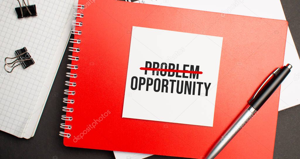 Problem Opportunity sign on sheet of paper on the red notepad with pen