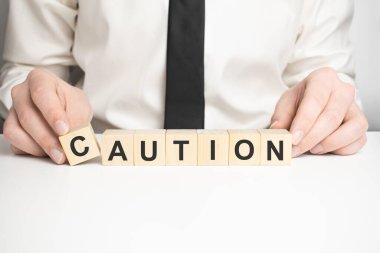 Adam ahşap bloklarla kelime CAUTION yaptı