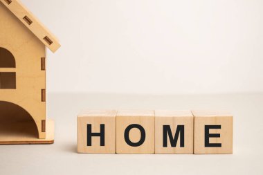 Tahta ev ve küp bloklar tahtanın üzerinde ev yazılıyor. Konut kredisi veya ev satın almak için tasarruf kavramı.