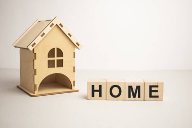 Tahta ev ve küp bloklar tahtanın üzerinde ev yazılıyor. Konut kredisi veya ev satın almak için tasarruf kavramı.