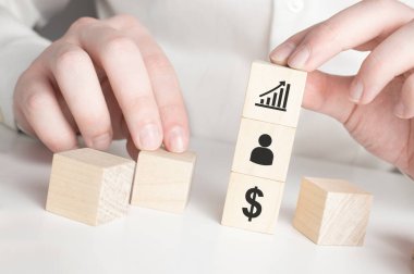 İş büyümesinin başarısı için dolar sembolü simgesine işaret eden oklarla el ele tutuşan tahta küp