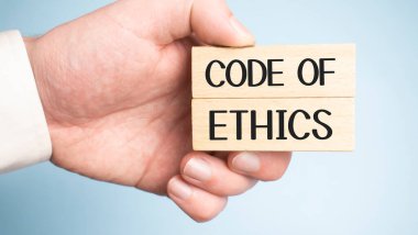 Ahlak Yasası olan iki tahta çiviyi tutan erkek eller