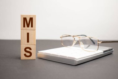 Yanlış. Küplü ahşap masa. Hesap makinesinin yanındaki not defterinde ne varsa tahta bloklar üzerine metin