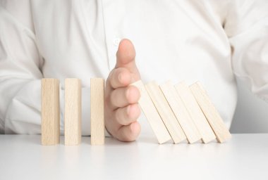 Krizi durdurma konsepti. Mavi arka planda ahşap blokları tutan eller. Kapat..
