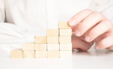 Tahta blokları merdiven şeklinde istiflemek için. İş geliştirme, strateji kavramı. Başarı temeli oluşturuluyor