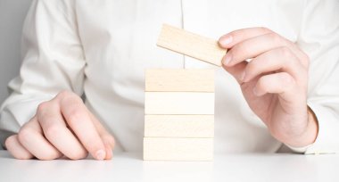 Adam el kopya alanı ile beyaz arka plan üzerinde izole bir merdiven şeklinde ahşap blok koymak. Başarı temel yapı kavramı