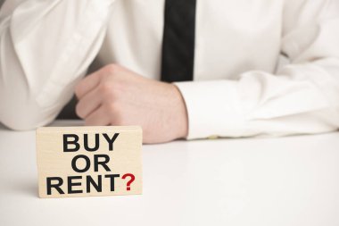 Satış, Kira Emlak Konsepti. Buy Kira kelimesi tahta bloğa ve beyaz arka plandaki model eve yazılmıştır..