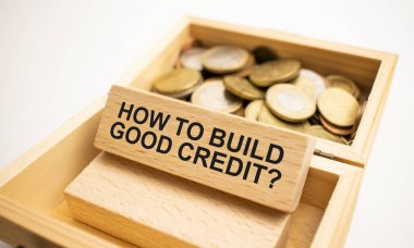 Para sikkeleri basamakları büyüyen basamaklar ve nasıl iyi kredi inşa edileceğine dair sözlerle dolu tahta küp blokları istifliyor. Yatırım ve tasarruf kavramı