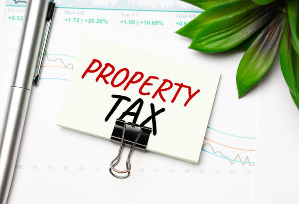 Налог на имущество с ручкой и очками на белом фоне