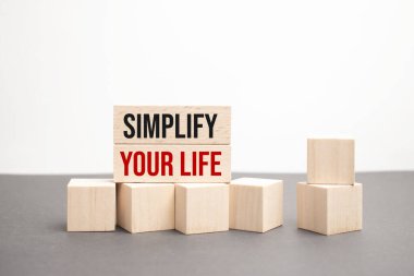 Hayatını basitleştir. Bir fincan kahve, minimalizm, iş ve yaşam tarzı konsepti ile özgün harflerle yazılan ahşap harflerle özetlenmiş ilham verici kelime.