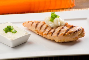 Arka planda turuncu kumaşlı tavuk göğsü.