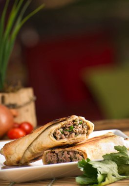 Kafta lafeh üzerinde beyaz plaka yeşil bulanık arka plan. Arap yemekleri Akdeniz.