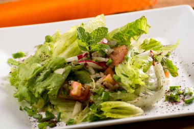Turuncu kumaşlı Arap salatası ve beyaz tabak, domates, soğan, soğan, maydanoz, turp, nane, zeytin, tavuk..