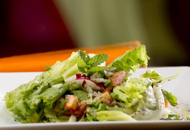 Turuncu kumaşlı Arap salatası ve beyaz tabak, domates, soğan, soğan, maydanoz, turp, nane, zeytin, tavuk..