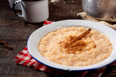 Kırsal tabakta servis edilen tatlı pirinç, arka planda demlik ve kahve fincanları geleneksel Brezilya yemekleri..
