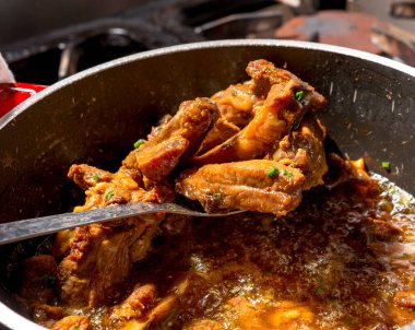 Kızarmış domuz pirzolası ile karıştırılmış kırmızı tava..