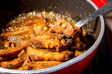 Kızarmış domuz pirzolası ile karıştırılmış kırmızı tava..