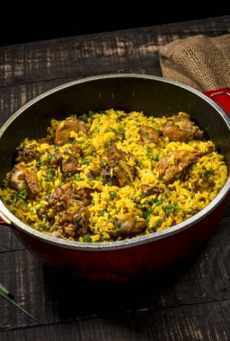 Tipik Brezilya yemeği (galinhada) safran çeşnili tavuk ve kırmızı tavada pirinçli köy ahşabı. 