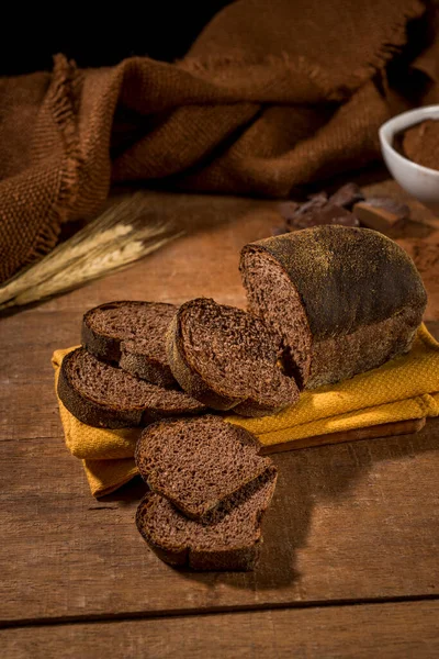 用可可豆和巧克力制成的切片面包 用黄布铺在带有配料的乡村木桌上 — 图库照片