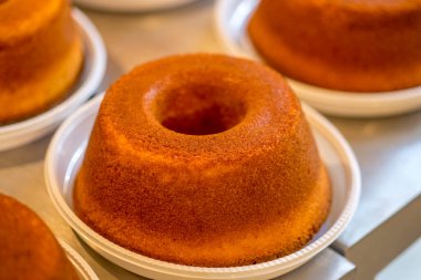 Köy ahşabında dilimsiz mısır keki ve mısırlı kumaş, tabakta dilimler ve arka planda pasta..