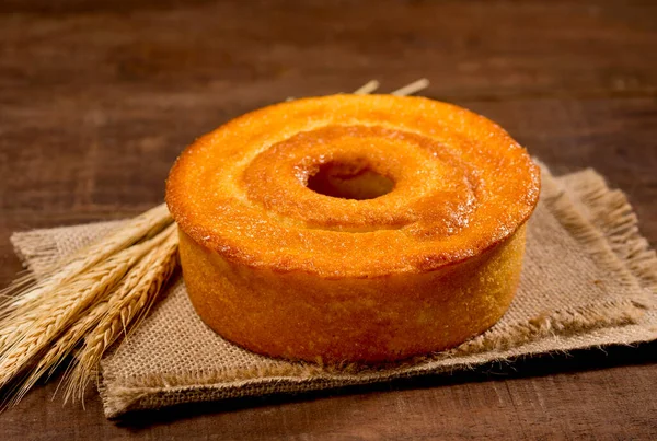 没有切片的玉米蛋糕 在乡村木料和带有玉米的织物上 切片在盘子里 以蛋糕为背景 — 图库照片