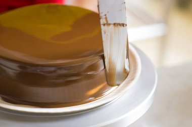 Çikolata kaplı turtaya spatula uzatıyorum.