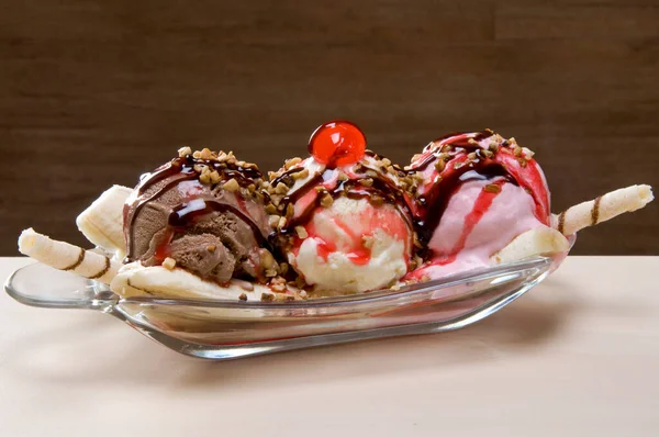banana split with 3 balls of ice cream with chocolate and banana split with 3 balls of ice cream and strawberry syrup icing