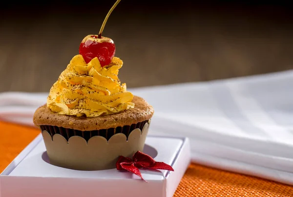 Cupcake Kuning Dengan Cherry Pada Latar Belakang Oranye — Stok Foto