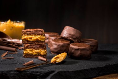 Sütlü kurabiyeler. Siyah taşın üstüne yakın plan. Çikolata kaplı vanilyalı kurabiyeler.