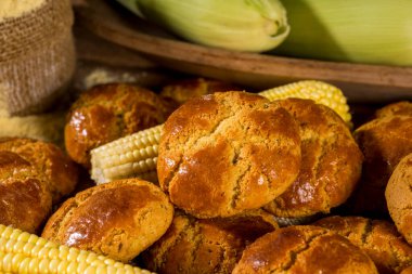 Arkaplanda mısır unu ve mısır unuyla ahşap üzerinde mısır kurabiyeleri - broa de milho - tipik Brezilya ve Portekiz bisküvisi