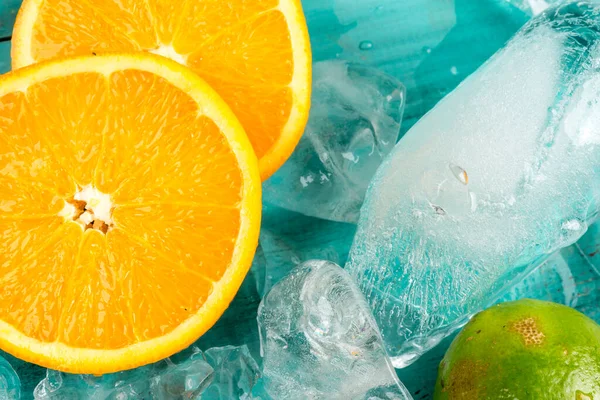 オレンジのスライスと青い木の背景の氷は — ストック写真