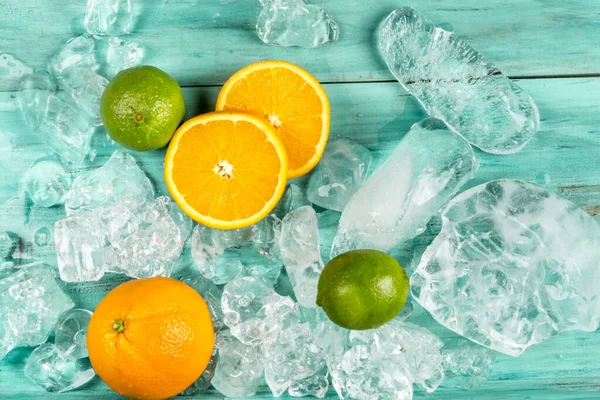 Orangenscheiben Tahiti Zitrone Limette Und Eis Auf Blauem Holzgrund Ansicht — Stockfoto