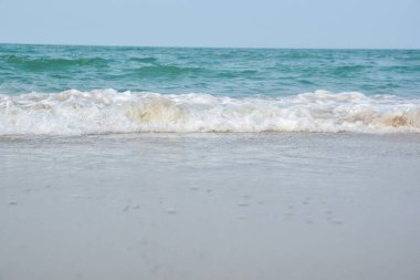 Deniz suyunun sahile vurduğu geniş açı görüntüsü, denizin beyaz süngeri, yaz doğası görüntü konsepti.